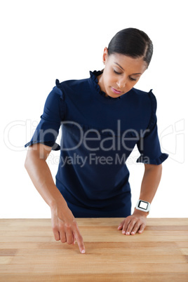 Businesswoman touching invisible screen on wooden table