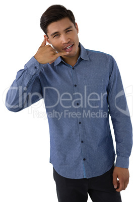 Portrait of businessman gesturing call hand sign