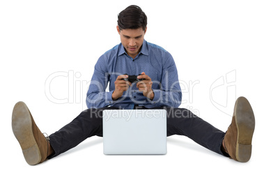 Full length of businessman playing video game on laptop