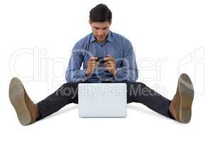Full length of businessman playing video game on laptop