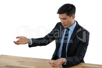 Young businessman gesturing at table during meeting