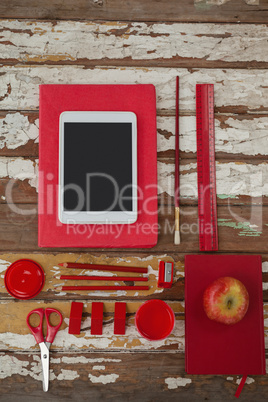 Various school supplies, apple and digital tablet on wooden table