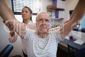 Male patient and female doctor with arms raised