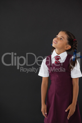 Schoolgirl standing against blackboard in classroom