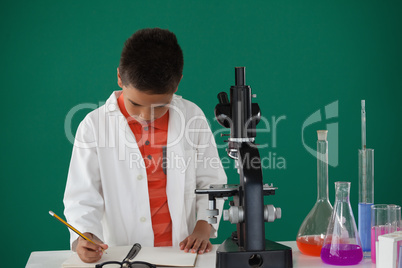 Schoolboy writing on book