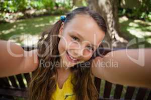 Portrait of playful girl sitting on bench
