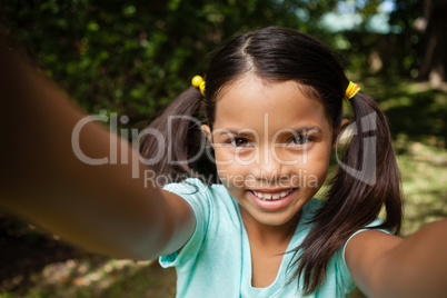 Close-up portrait of smiling girl with arms raised
