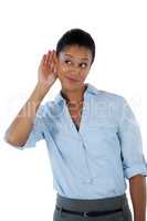 Businesswoman listening secretly with hands behind her ears