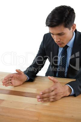 Businessman gesturing at table during meeting