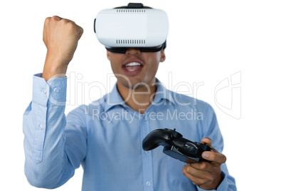 Businessman with vr glasses clenching fist while playing video game