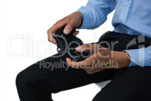 Mid section of businessman holding controller