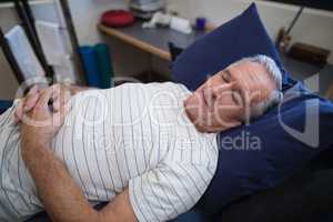 High angle view of senior man sleeping on bed