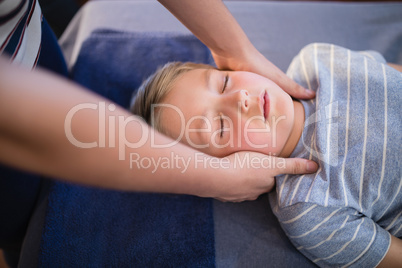 High angle view of female therapist giving neck massage to boy