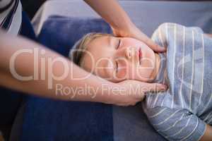 High angle view of female therapist giving neck massage to boy