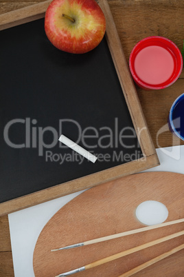 Various school supplies and apple on wooden table