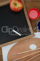 Various school supplies and apple on wooden table