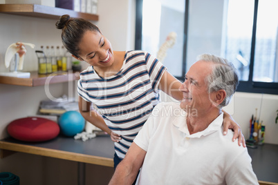 Smiling female doctor looking at senior patient