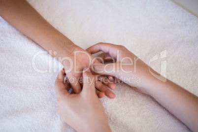 High angle view of female therapist massaging palm on white towel