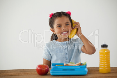 Schoolgirl having breakfast against white background