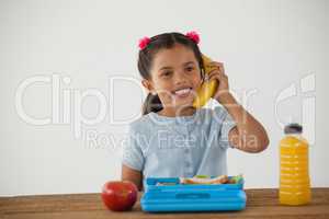 Schoolgirl having breakfast against white background
