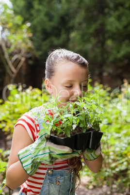 Girl smelling plants with eyes closed