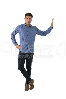 Portrait of young businessman standing with hand on hip
