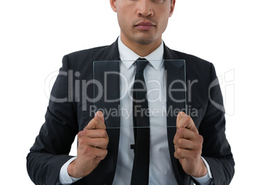 Mid section of businessman holding transparent interface