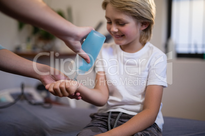 Cropped hands of female therapist pouring scanning gel on wrist