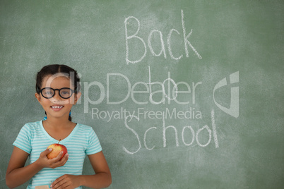 Young girl in spectacles hat holding apple