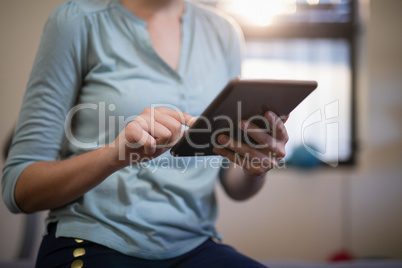 Midsection of female therapist using digital tablet