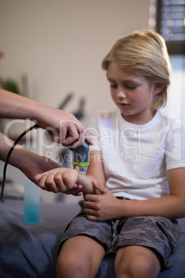 Cropped hands of female therapist pouring scanning wrist