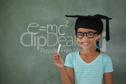 Young girl with graduation hat holding chalk