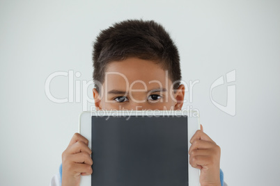 Schoolboy holding digital tablet against white background