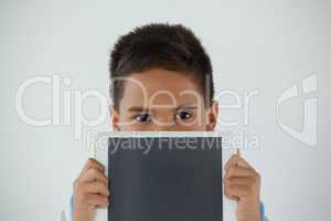 Schoolboy holding digital tablet against white background