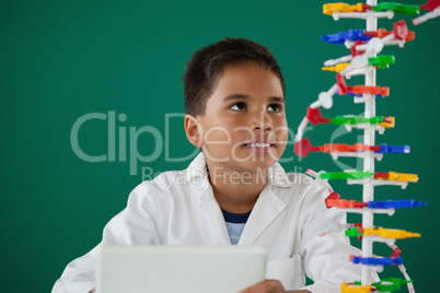 Smiling schoolboy experimenting molecule model in laboratory