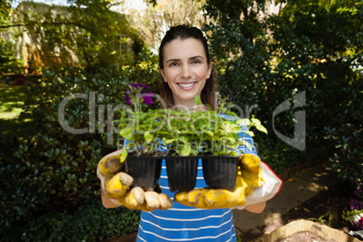 Portrait of smiling beautiful woman showing seedlings