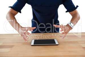 Frustrated executive trying to hold the digital tablet