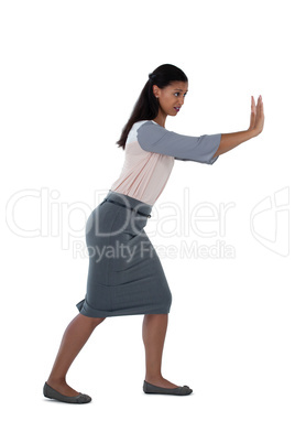 Businesswoman pushing against white background