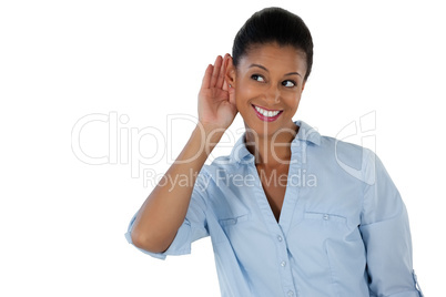 Businesswoman listening secretly with hands behind her ears