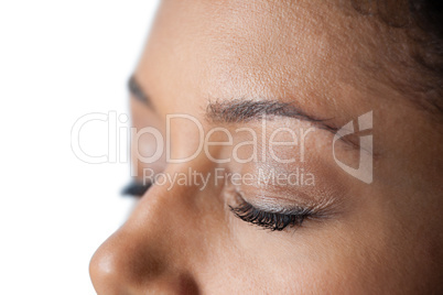 Closed womans eye and nose against white background
