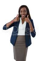 Portrait of smiling businesswoman showing thumbs up