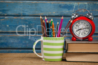 Alarm clock, books and pen holder
