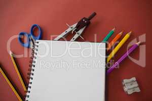Various school supplies arranged on red background