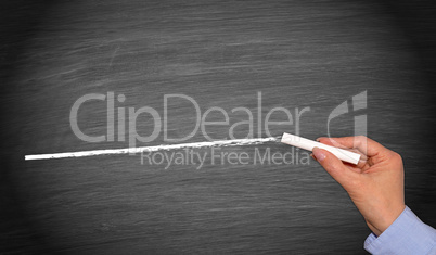 Hand with chalk drawing white line on empty chalkboard