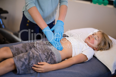 High angle view of female therapist examining stomach