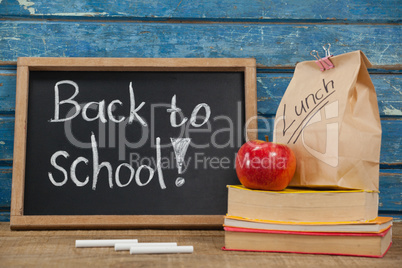 Apple, lunch bag, books and slate with back to school text