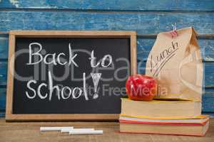 Apple, lunch bag, books and slate with back to school text