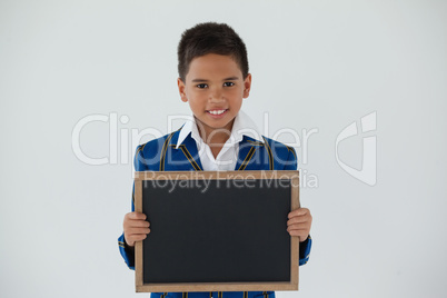 Schoolboy holding blank writing slate against white background