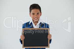 Schoolboy holding blank writing slate against white background