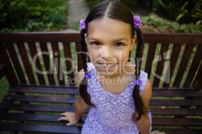 High angle portrait of smiling girl sitting on bench